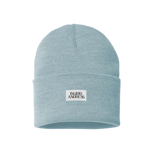 A light blue beanie with a branded patch on the front displaying the name 'Ingrid Andress'.
